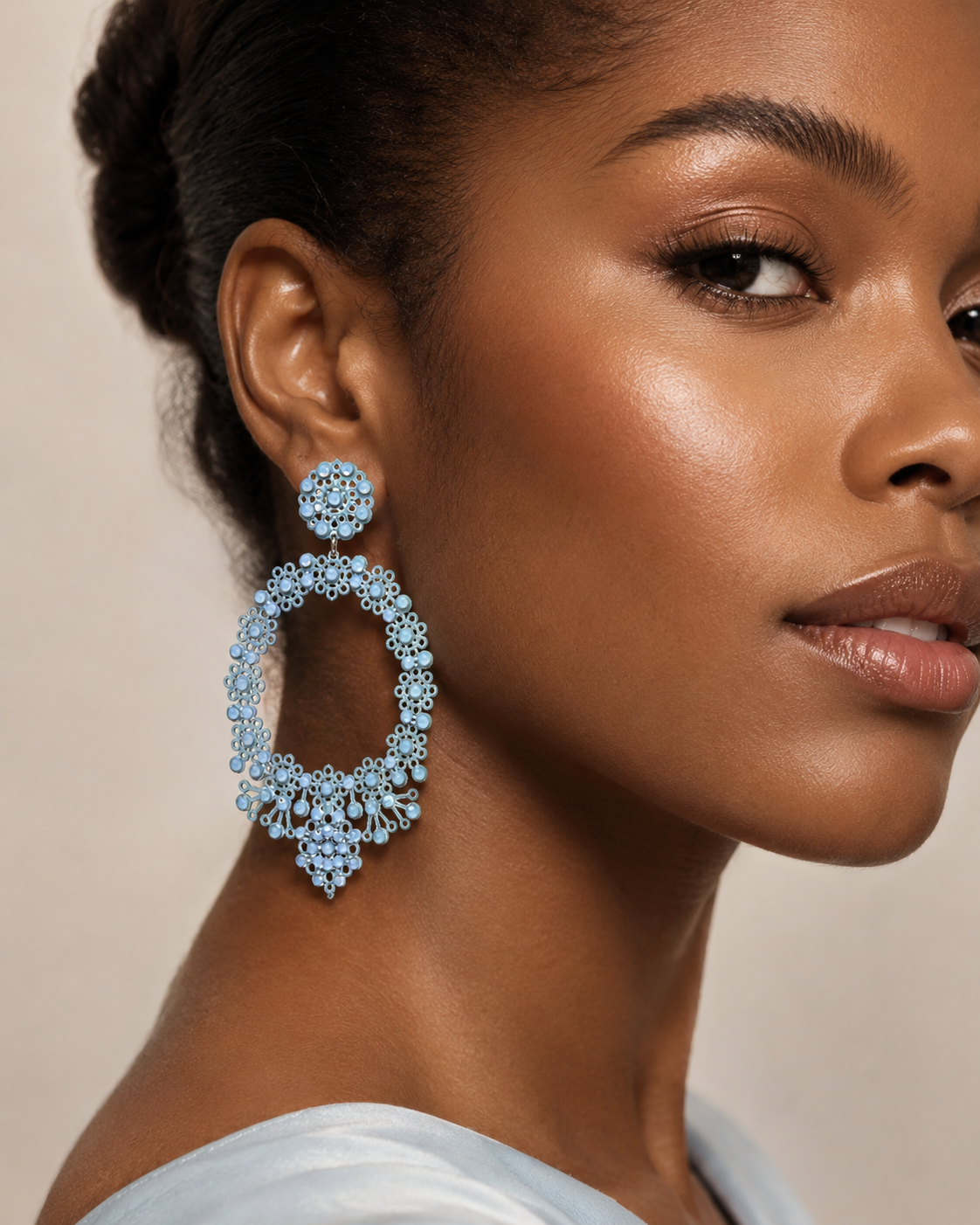 1. Immagine prodotto frontale
Light blue oval lace-inspired earrings with Swarovski crystals and enamelled metal laminae, INGA Sirmione.
2. Immagine sul manichino
Light blue oval statement earring shown on mannequin to illustrate real proportions and size.
3. Immagine editoriale indossata
Close-up editorial portrait of a model wearing light blue oval lace earrings with Swarovski crystals.